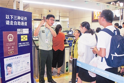 "昨日,在杭州萧山国际机场,杭州边检站检查员正在指导旅客如何通关更